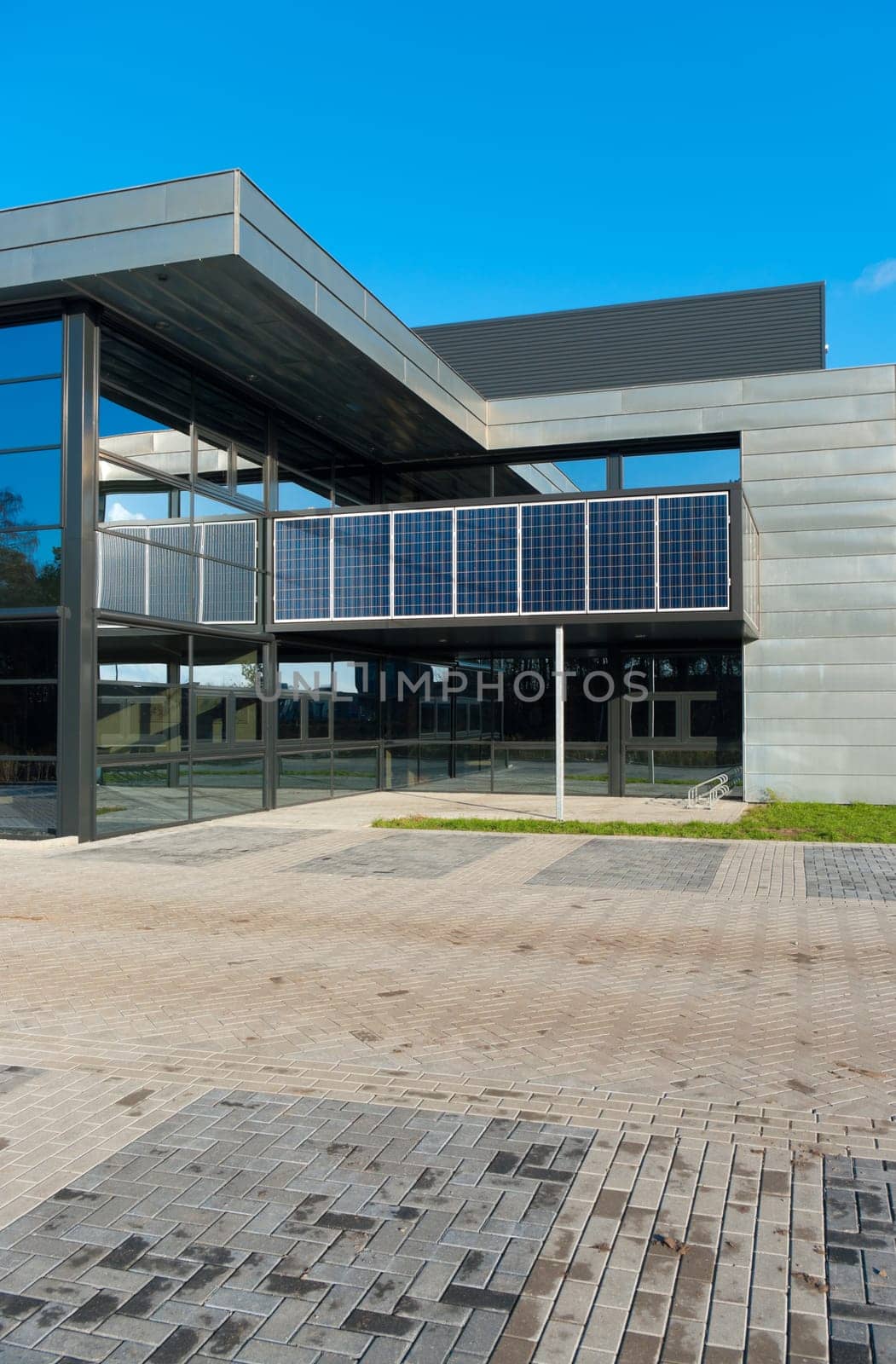 entrance of a modern office building with solar panels for energy supply