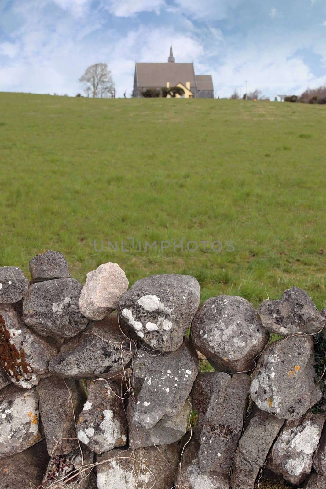 old stone wall with church in background in ballyvaughan county clare ireland