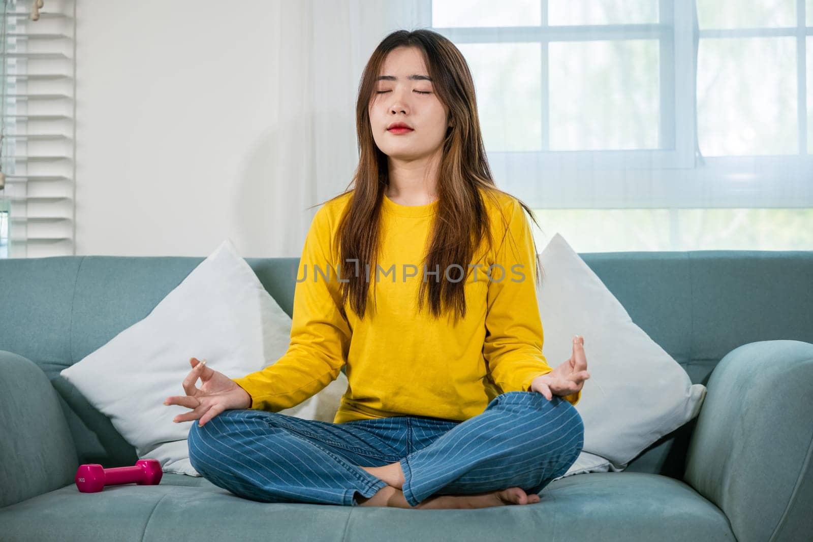 Young woman practise yoga and meditation in lotus position by Sorapop