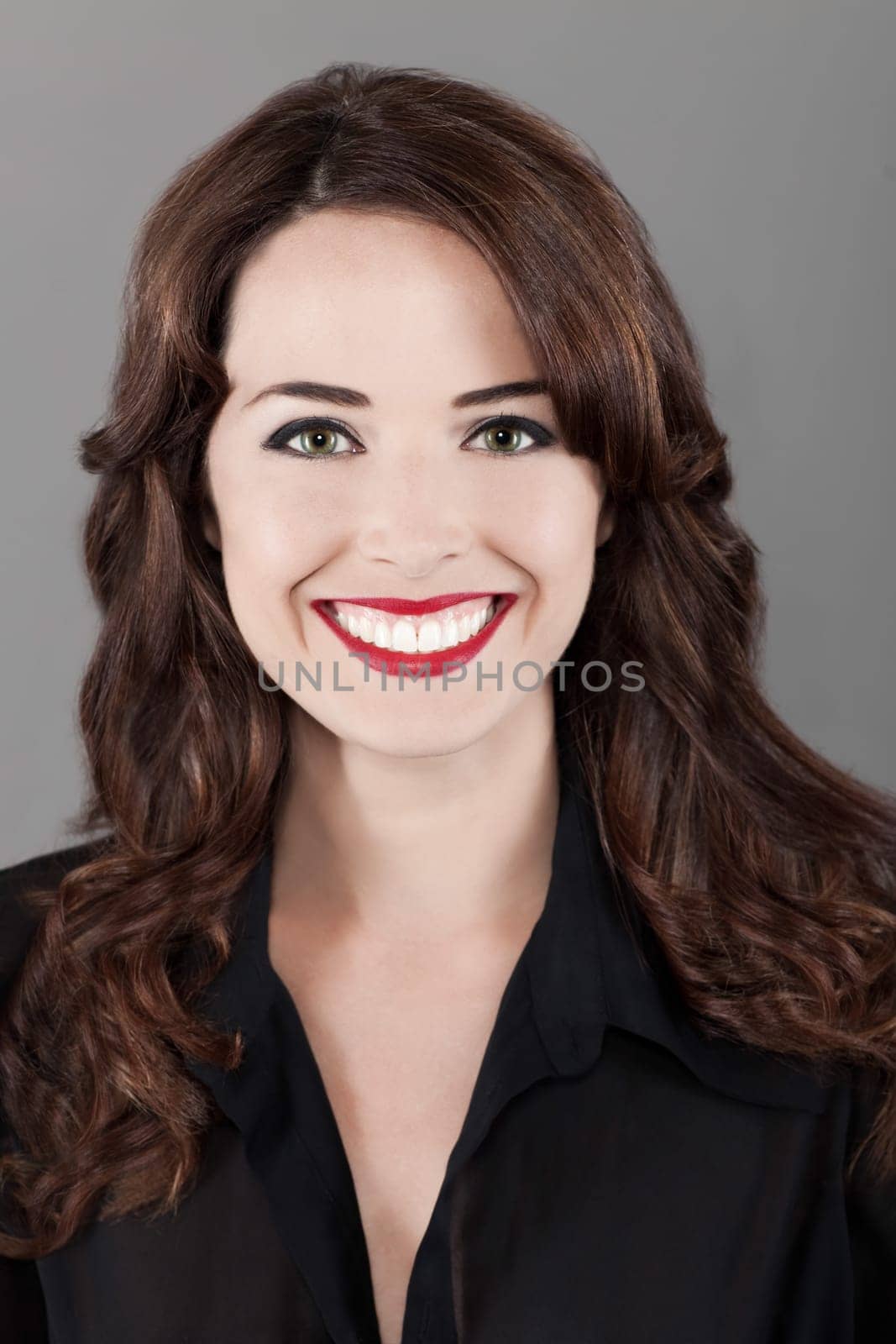 Closeup portrait of a beautiful happy brown haired woman toothy smiling isolated on gray background