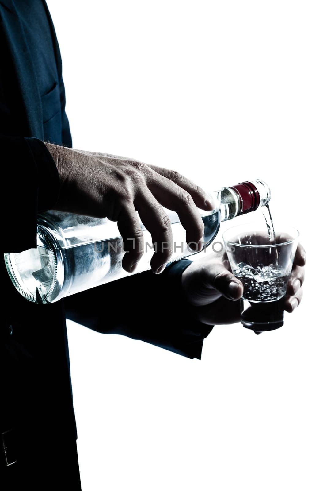 one caucasian man hands close up pouring white alcohol in a glass silhouette in studio isolated white background