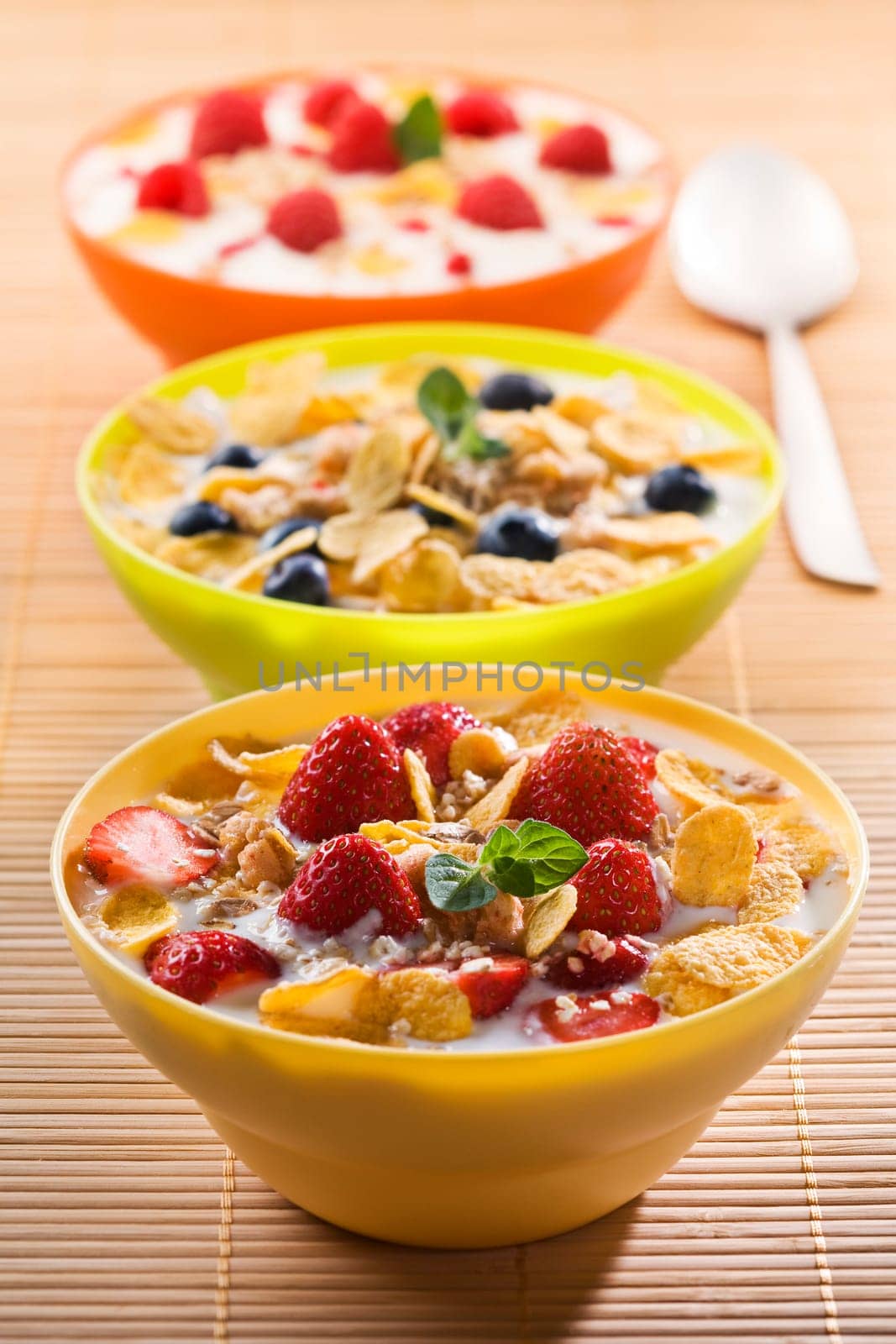 Corn flakes with berries and milk close up