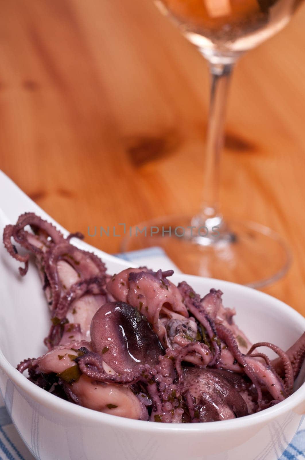 Antipasti Moscardini (squid) as a salad with a glass of wine