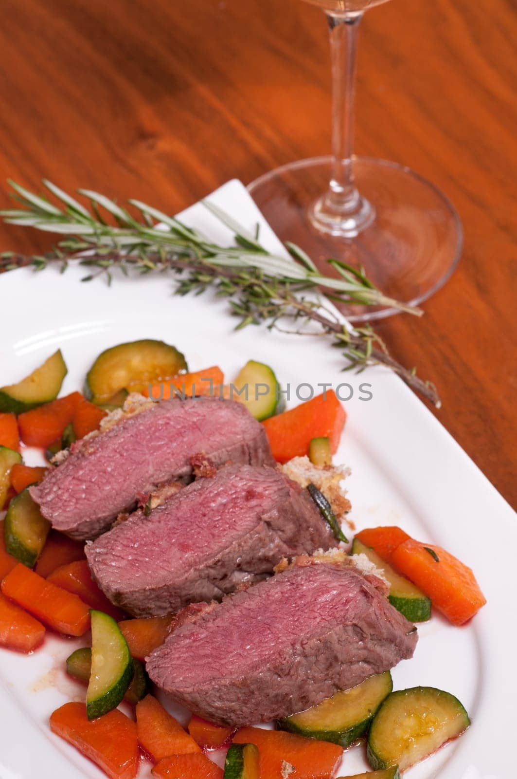 Saddle of lamb fillet with mustard and bread crust on glazed carrots and zucchini