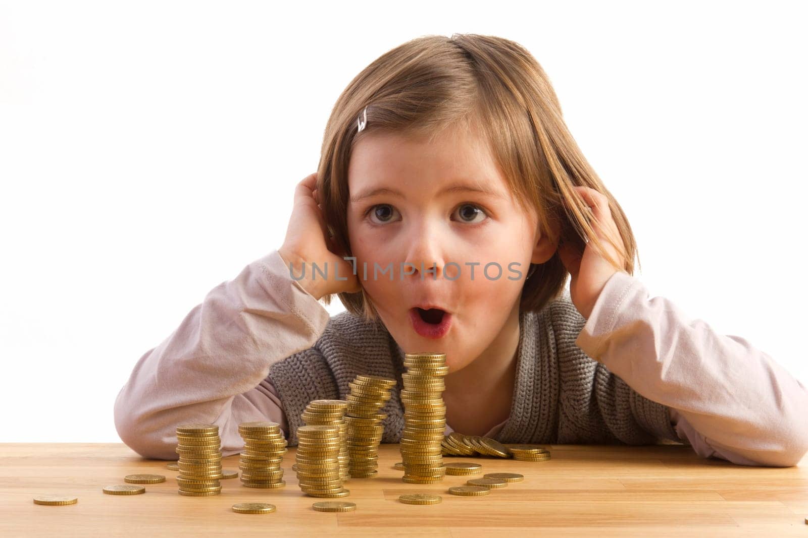 Girl looking in amazement at stacked money towers