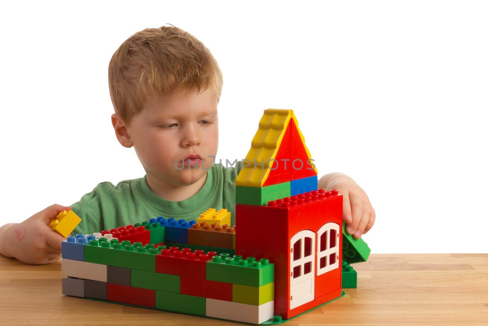Boy builds a house out of building blocks