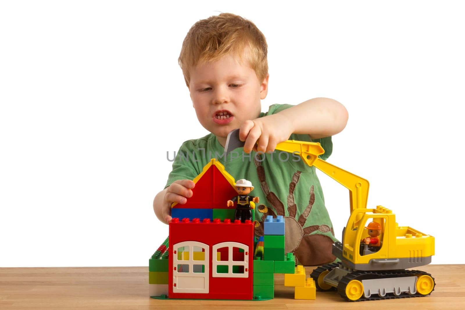 Boy builds a house out of building blocks