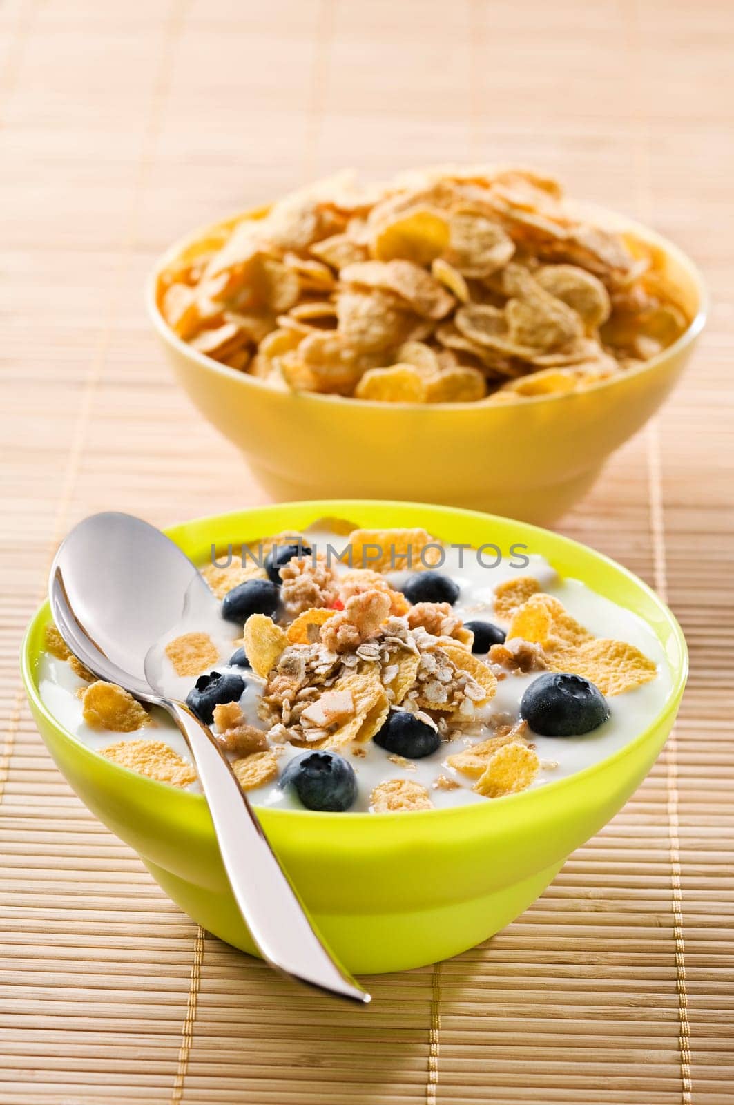 Corn flakes with blue berries and milk close up
