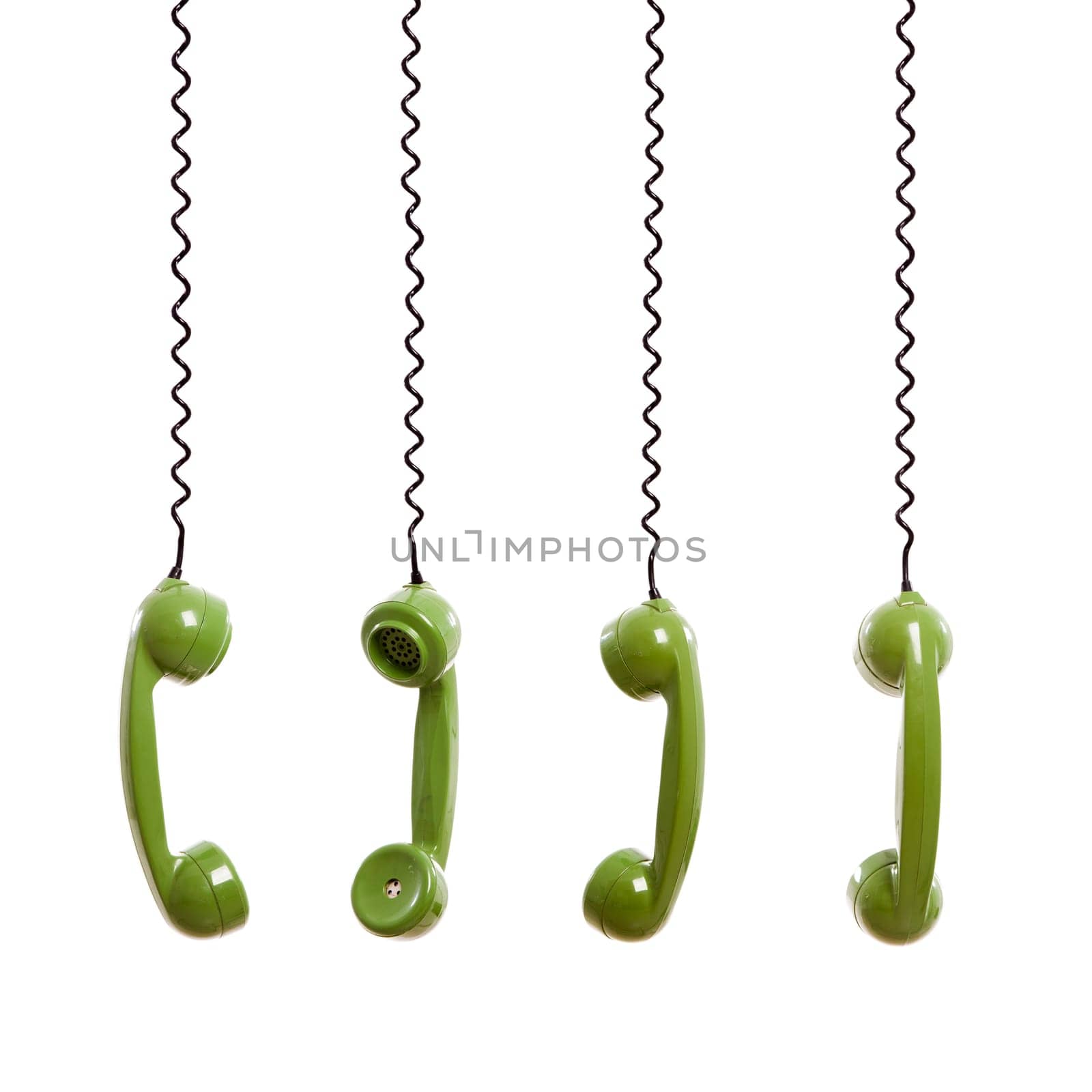 Handset piece from an old phone suspended by the phone cord, isolated on white background