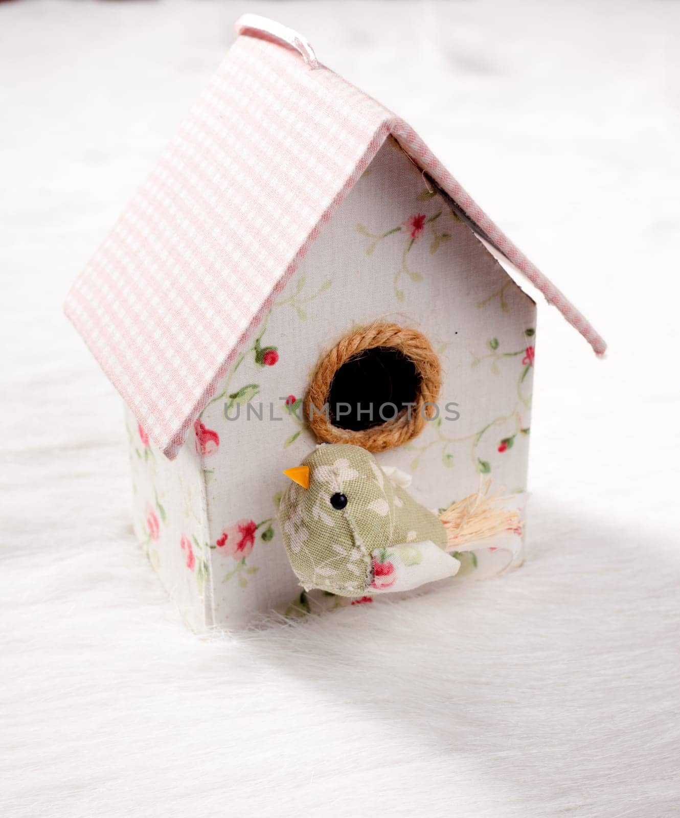 bird in a nest fabric house with round window in pastel colors
