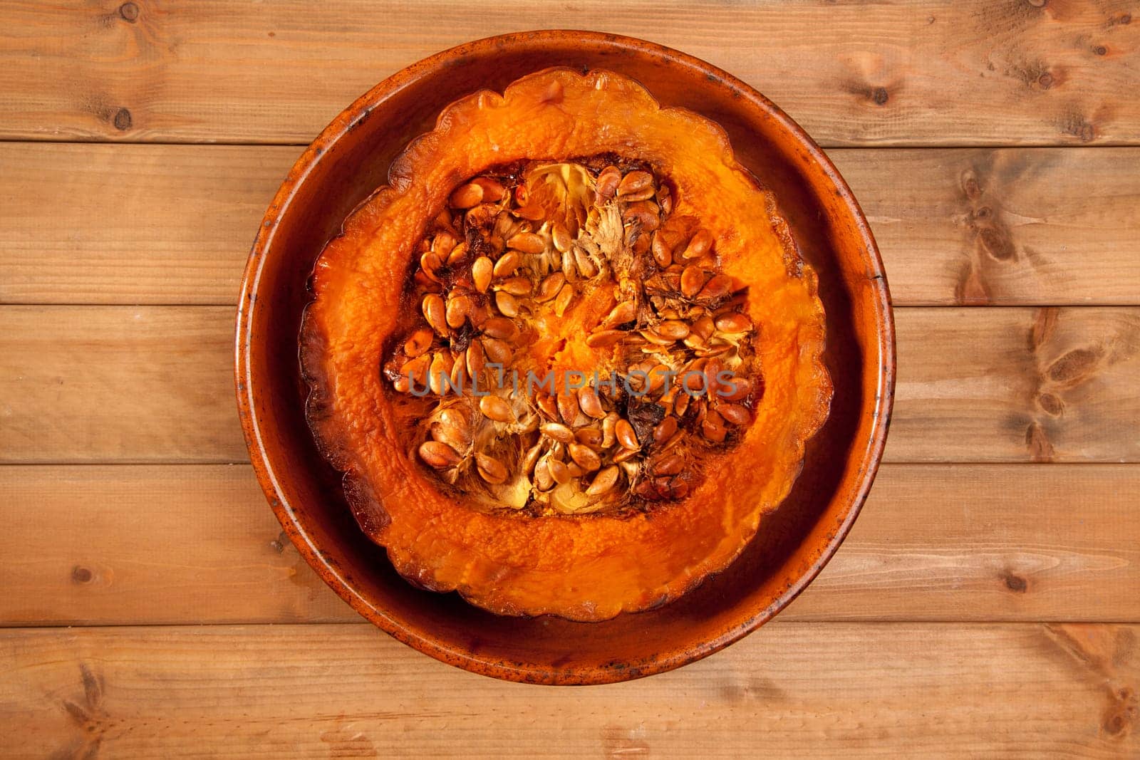 cutted half pumpkin roasted pumpkin on pottery clay dish