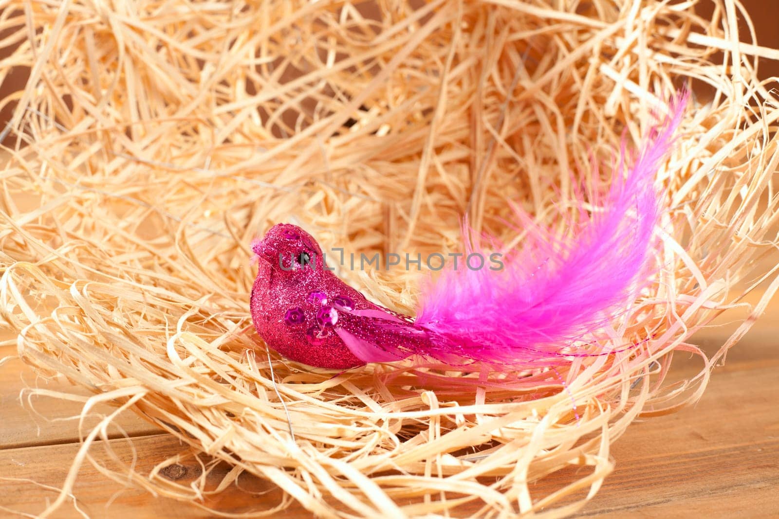 bird in straw nest with pink feathers and glitter body