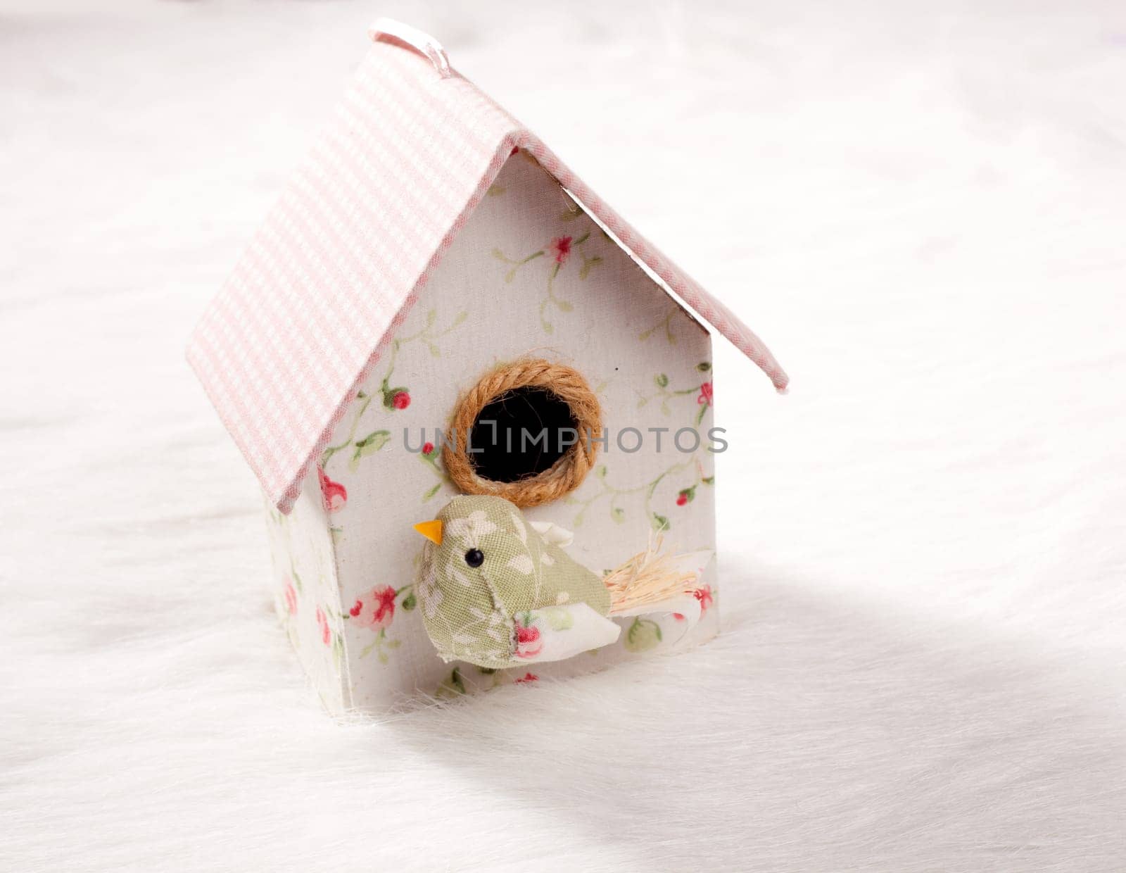 bird in a nest fabric house with round window in pastel colors