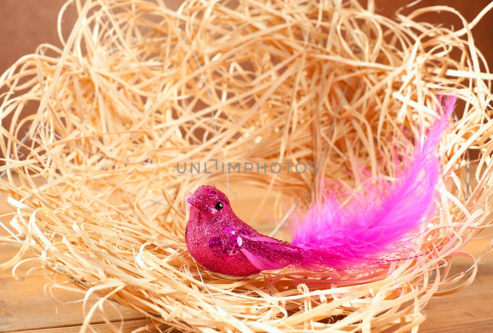 bird in straw nest with pink feathers and glitter body