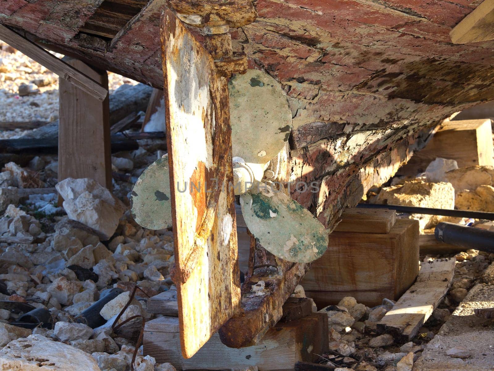 old rusty propeller ona rotten wooden boat