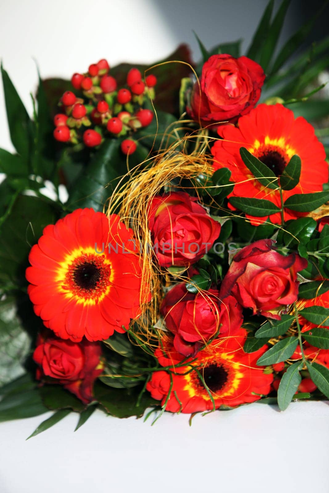 Colourful wedding corsage of orangey-red flowers in green foliage