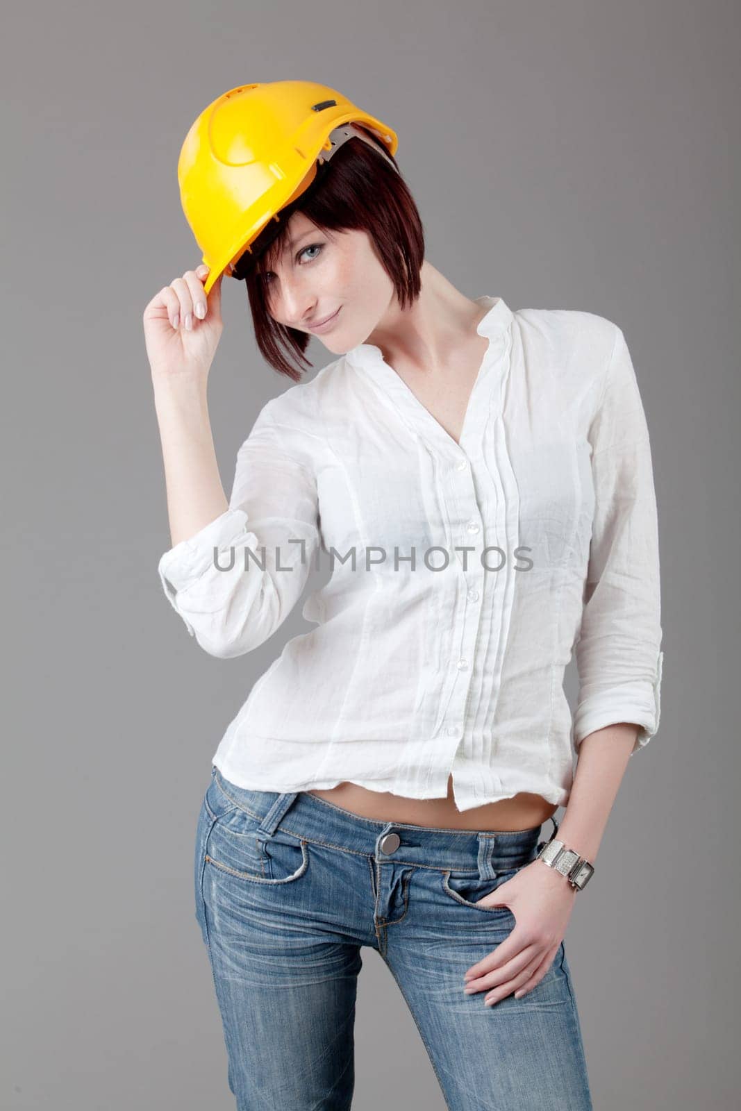 Portrait of confident female worker in yellow helmet. Engineer woman in yellow helmet