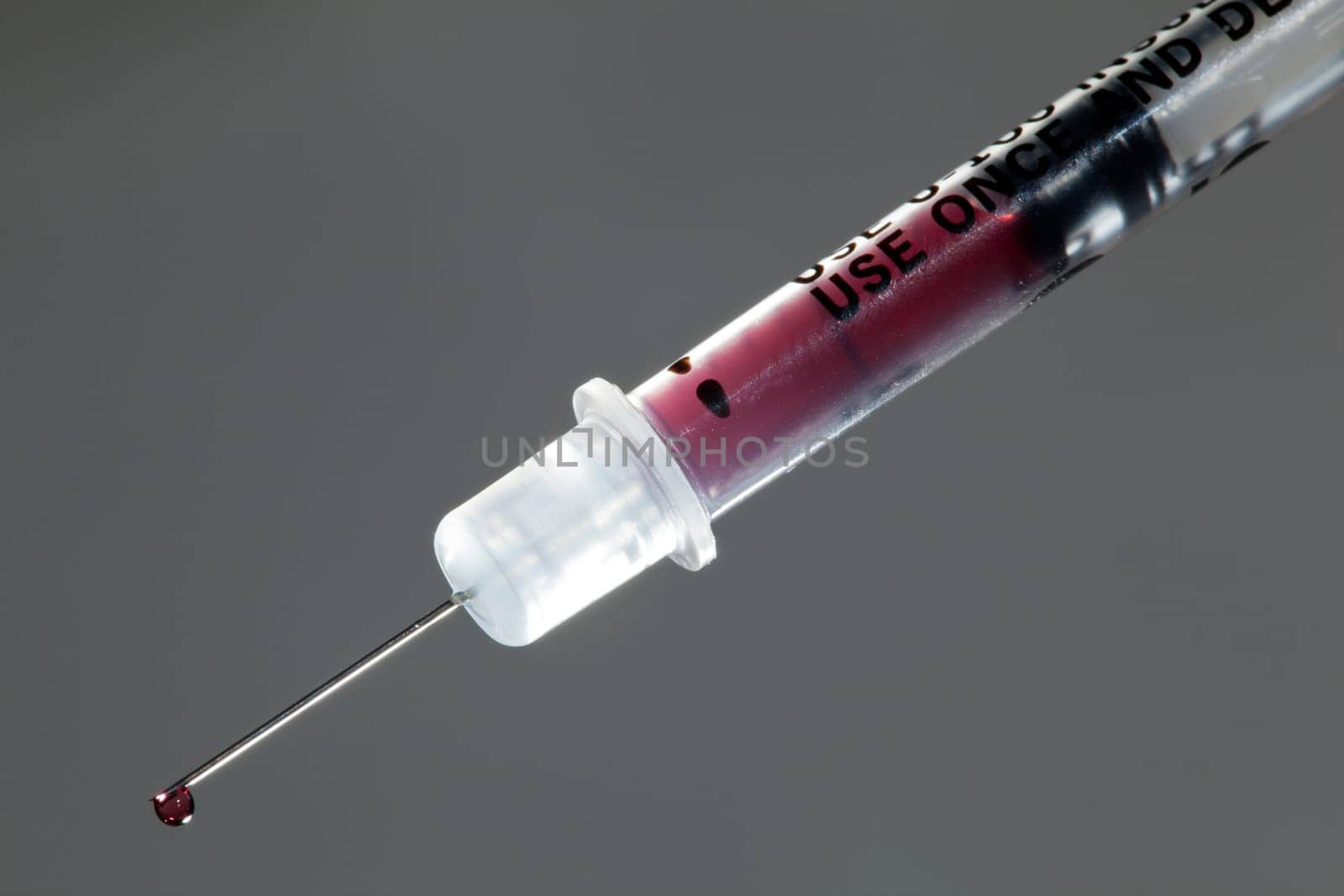 Macro of a drop of blood on the end of a hypodermic syringe needle