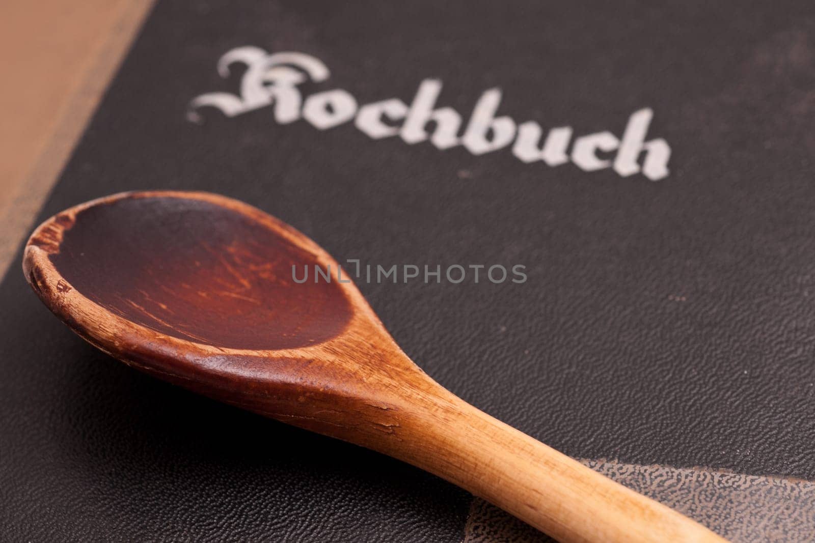 An old used wooden spoon and an old cookbook