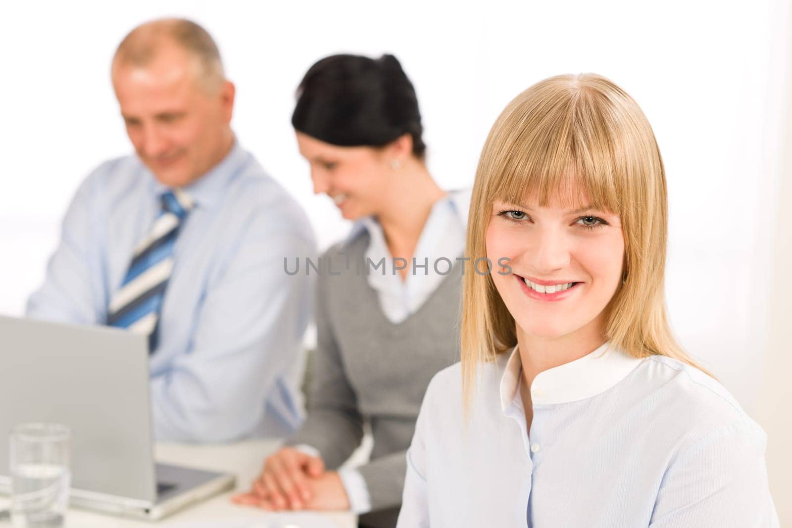 Businesswoman smiling at team meeting with colleagues