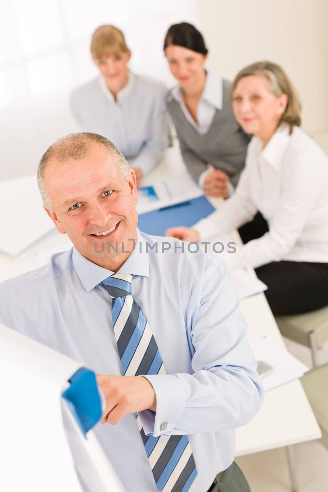 Giving presentation executive businessman pointing at flip chart team looking