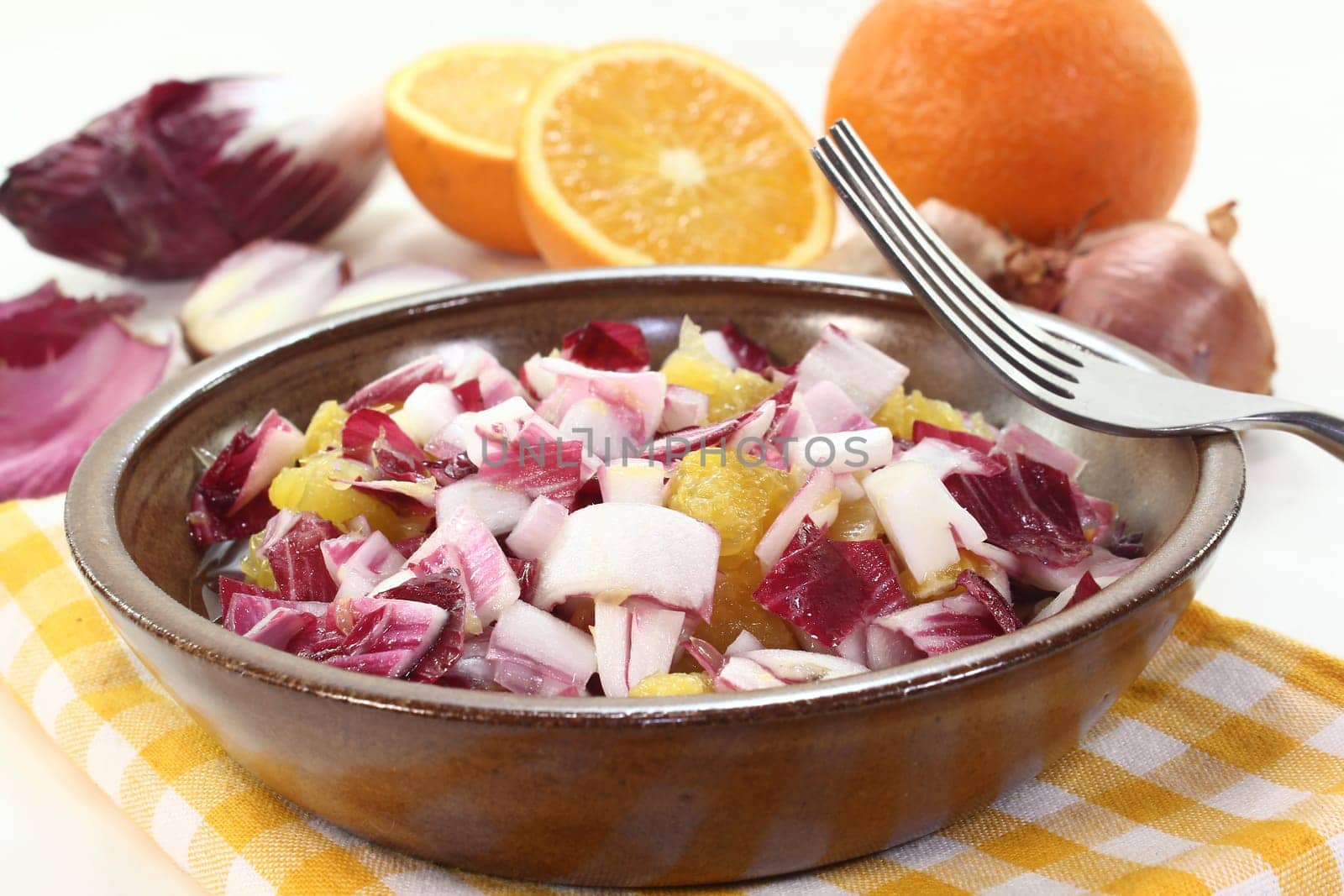 a bowl of chicory salad with shallots and orange
