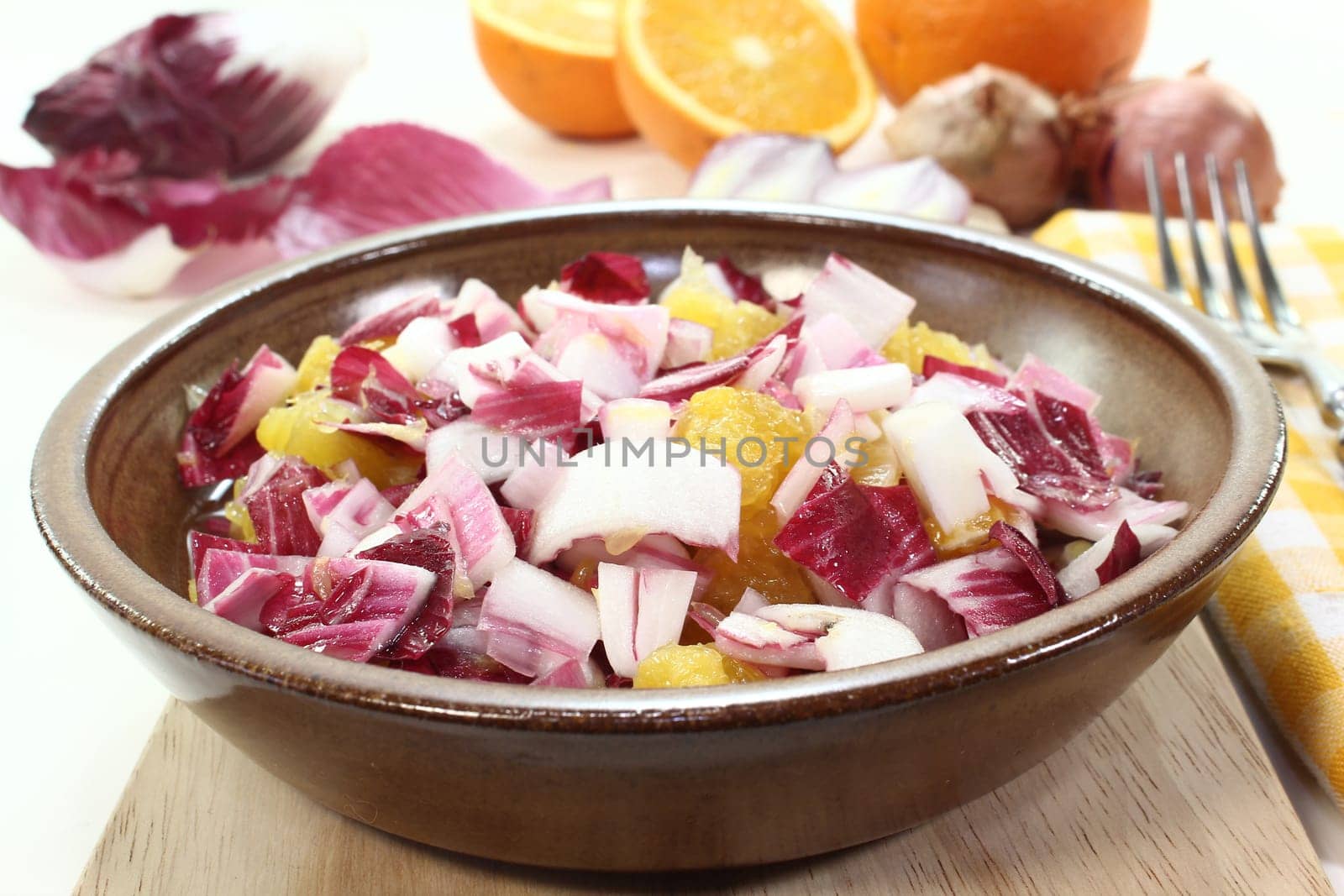 a bowl of chicory salad with shallots and orange
