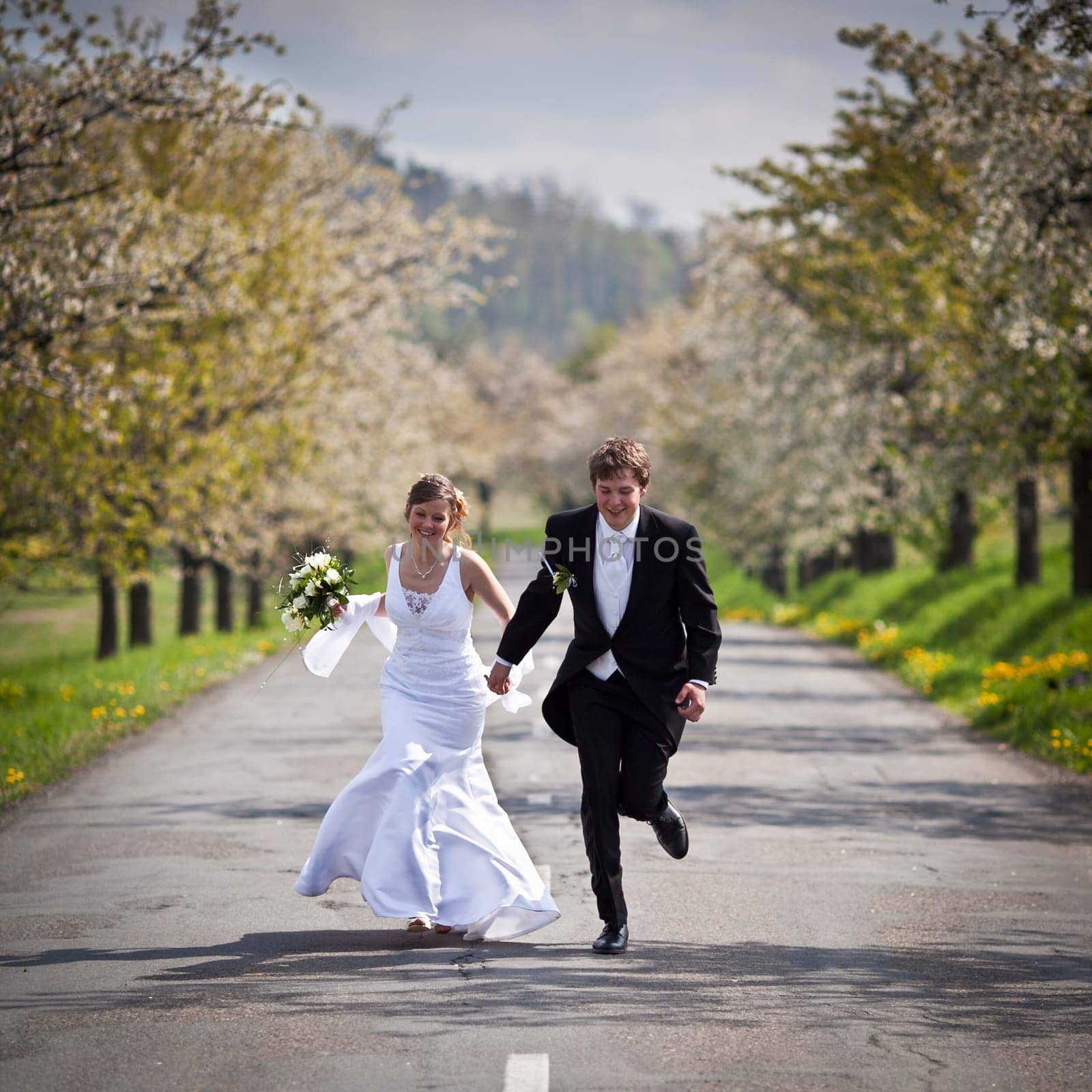young wedding couple - freshly wed groom and bride posing outdoors on their wedding day