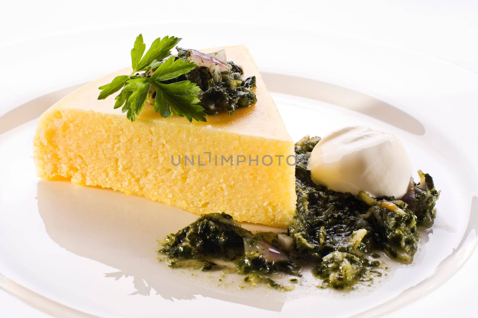 Fresh polenta with spinach and cream close up