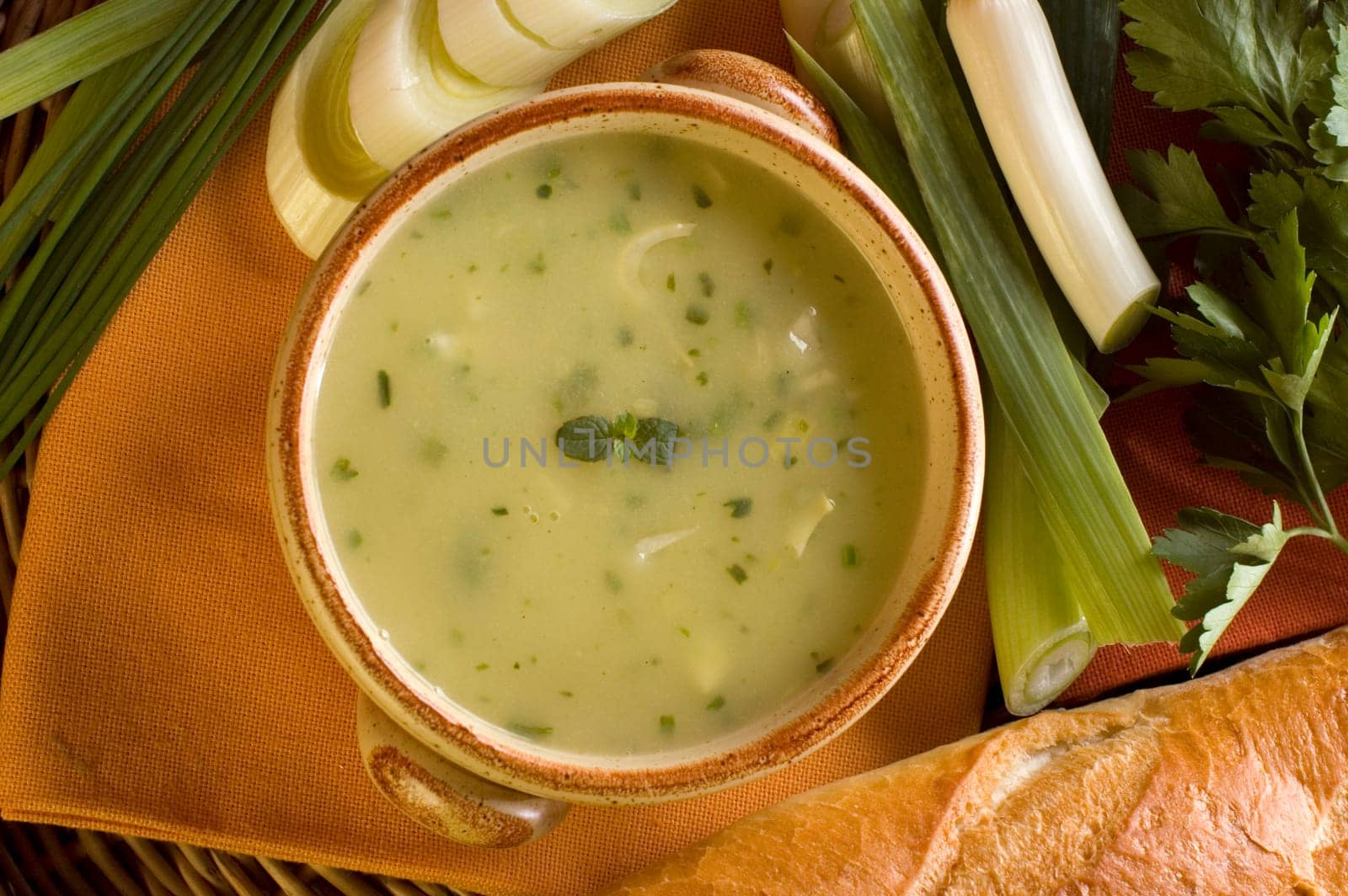 leek soup decorated with fresh vegetables and bread