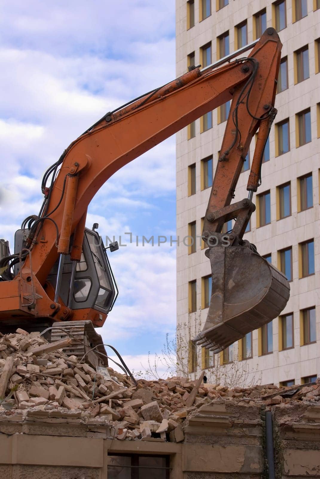 destruction made by excavator with new building in background