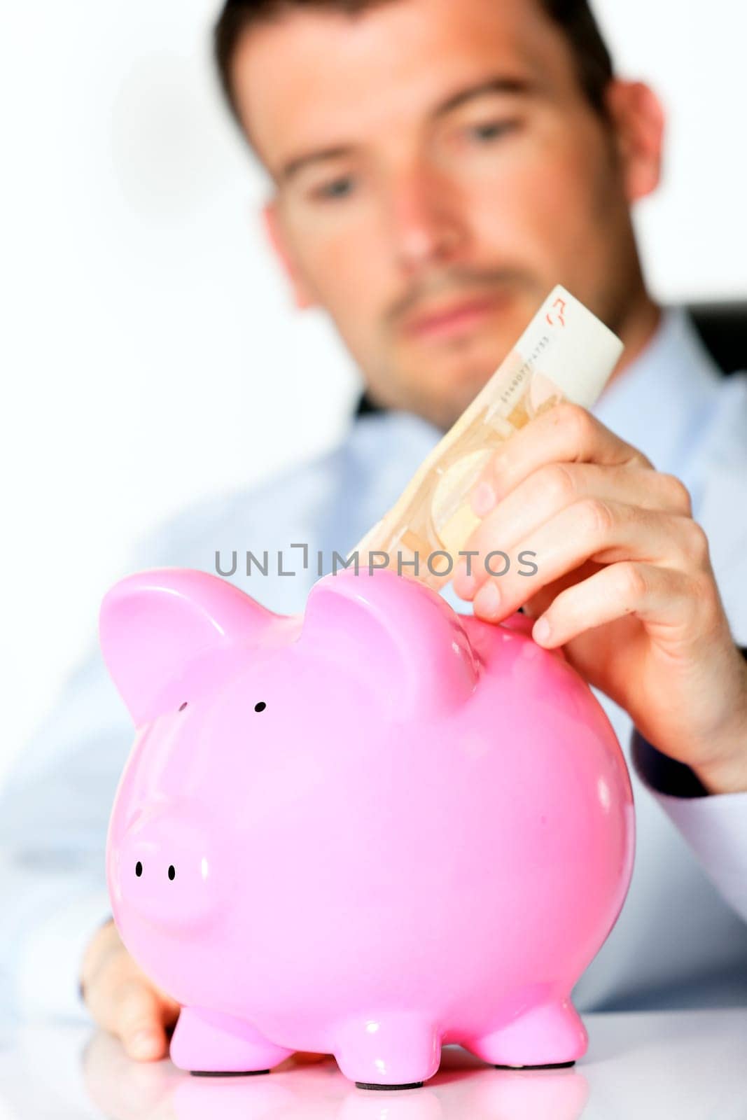 hand of man with bill and pink piggy bank