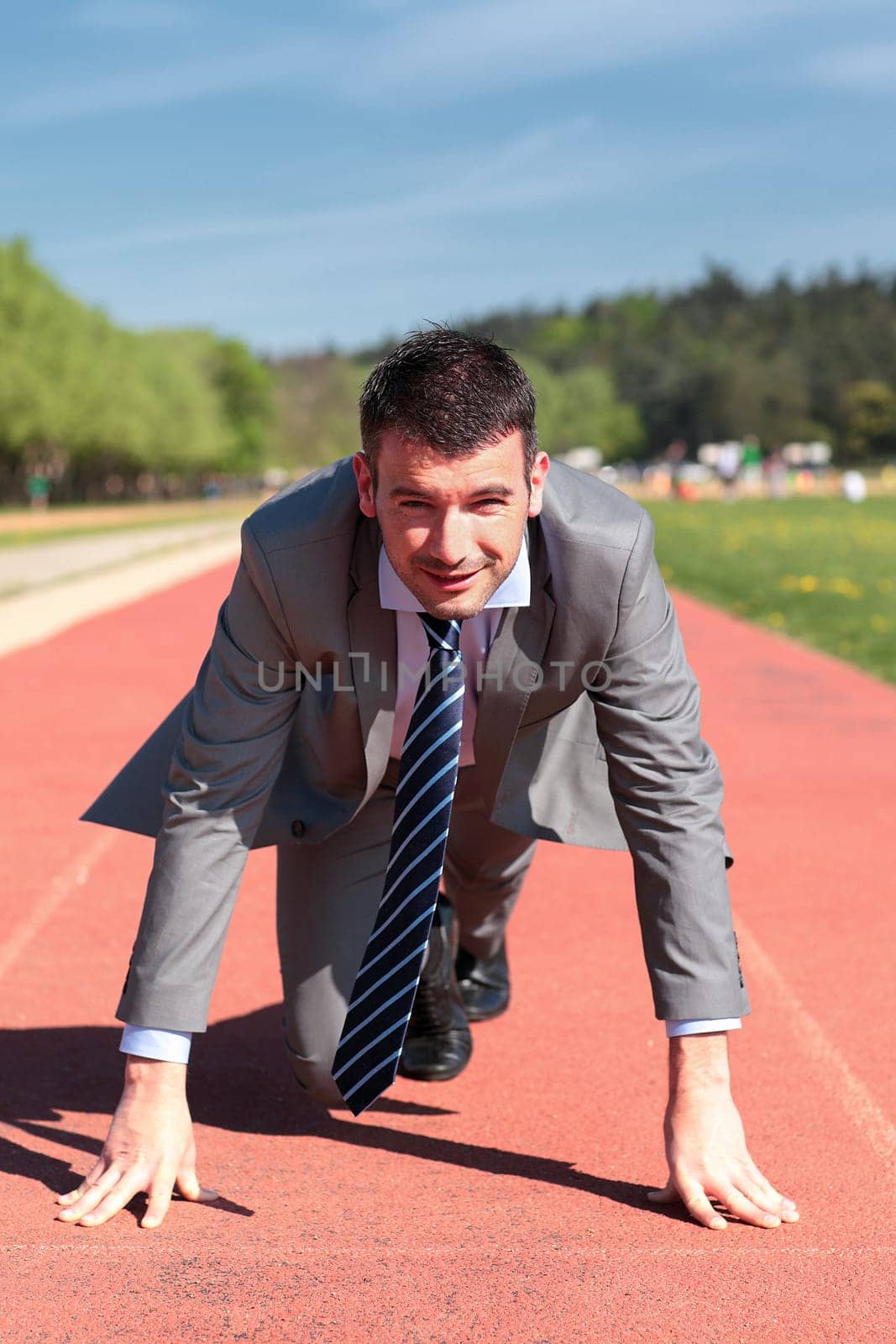 handsome businessman on a running track in summer