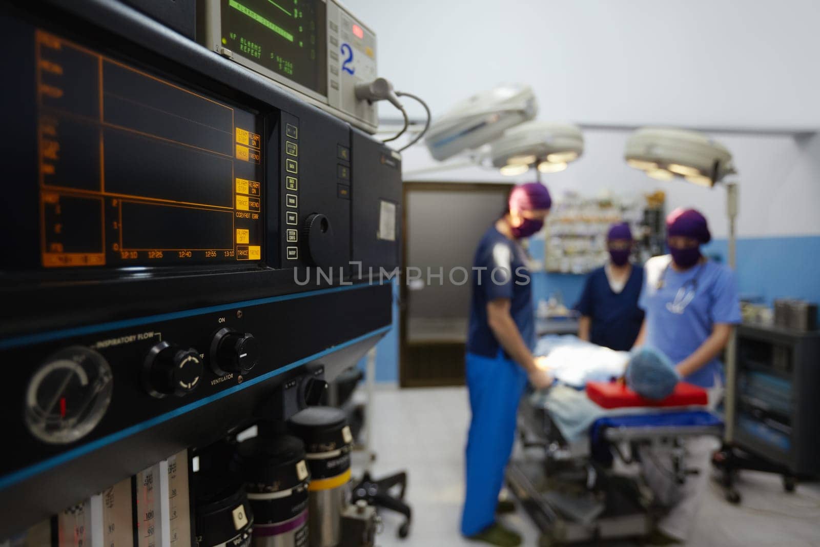 Team work with doctors, nurses, surgeons performing surgery on sick patient in hospital operation room. Focus on foreground