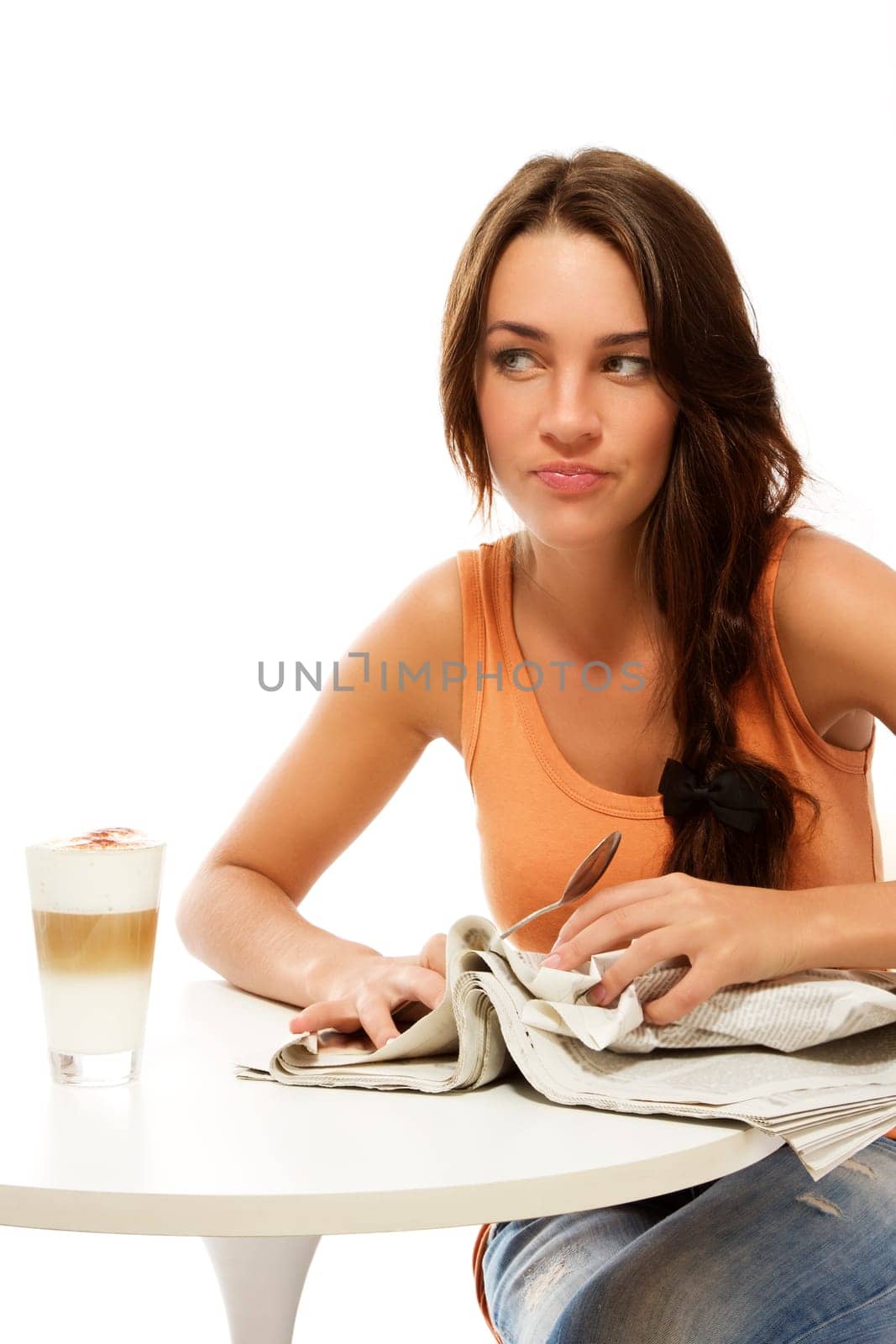 Angry young woman crumpling newspaper near latte macchiato coffee against white background