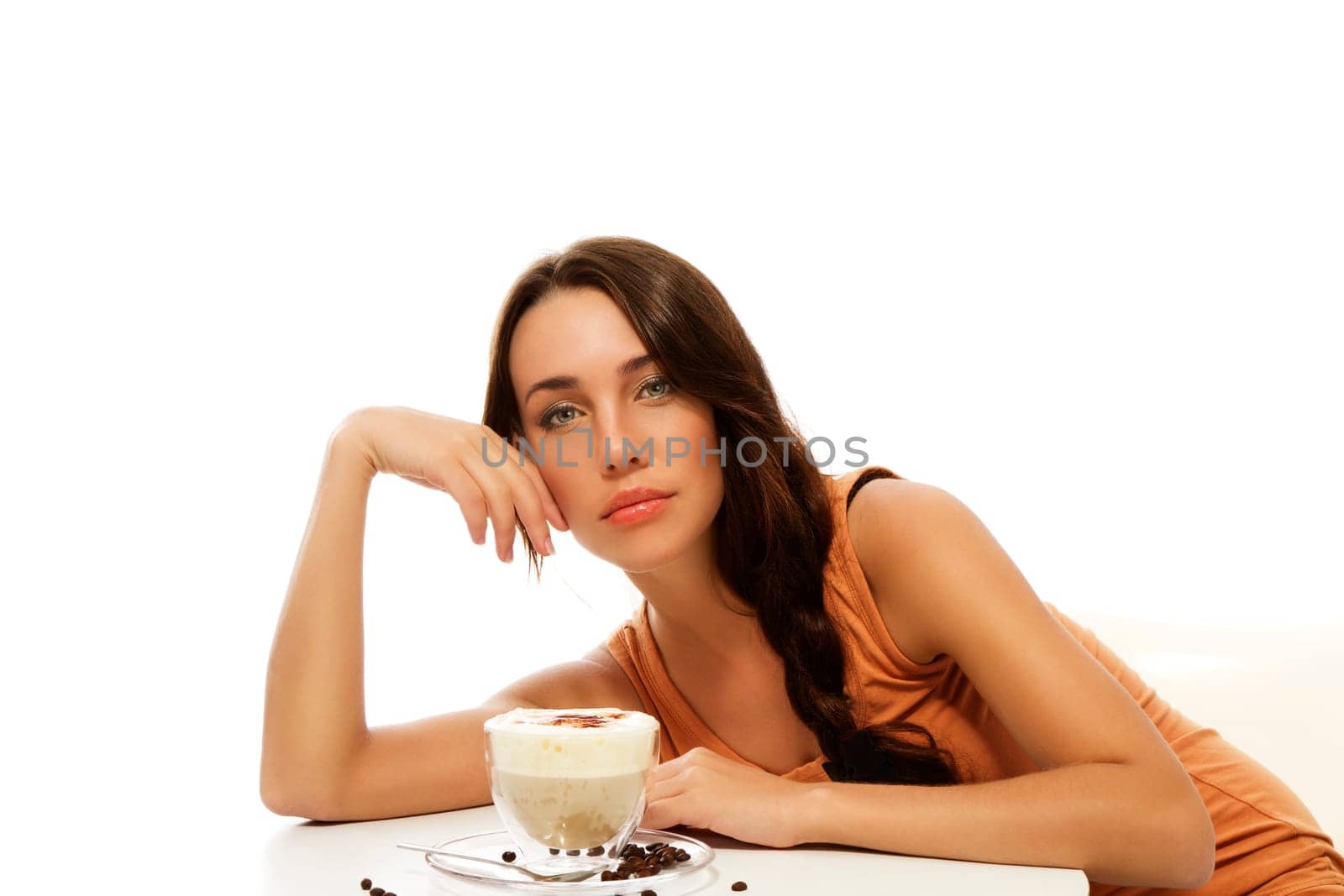 Beautiful woman leaning over cappuccino coffee against white background