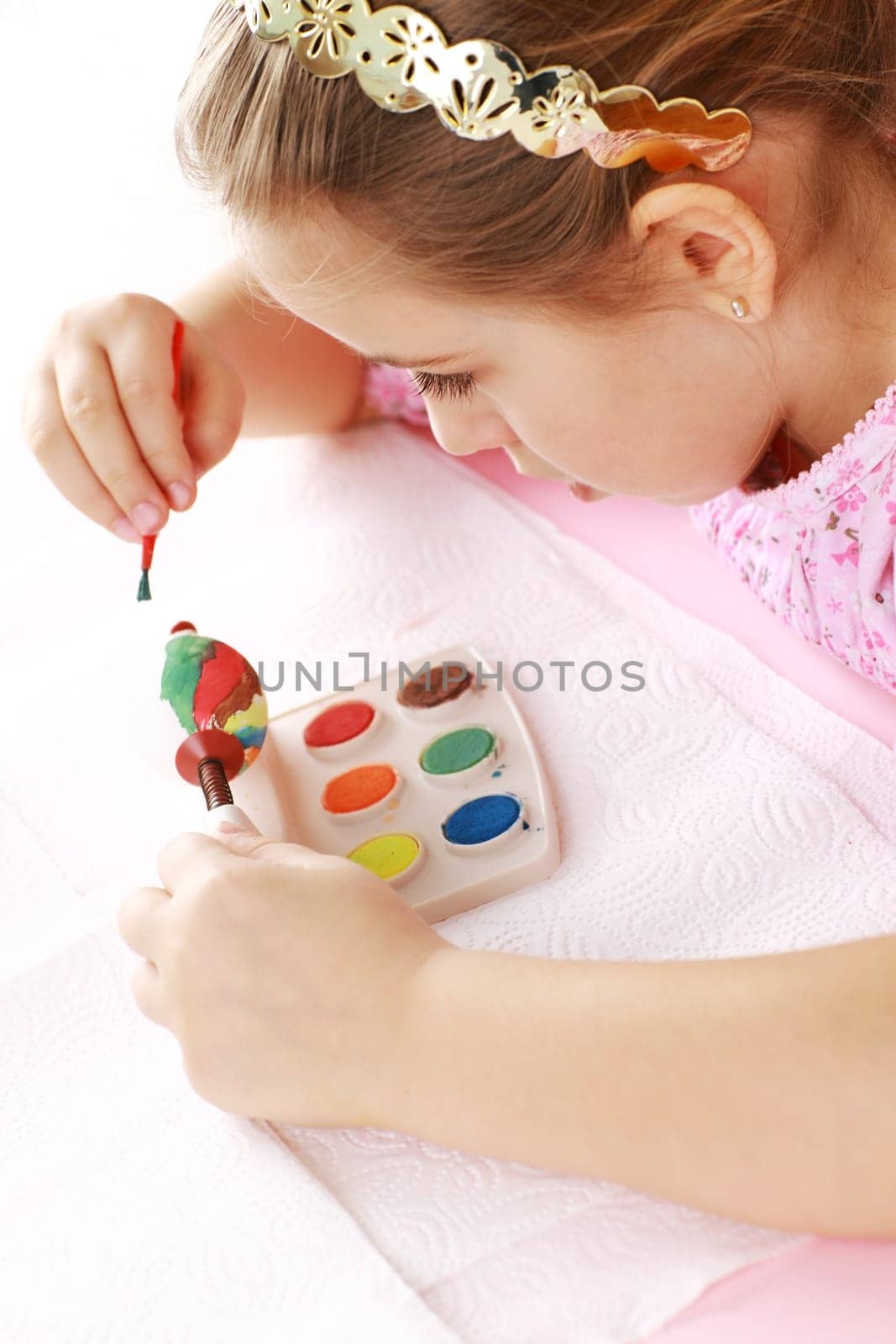Cute little girl painting Easter eggs