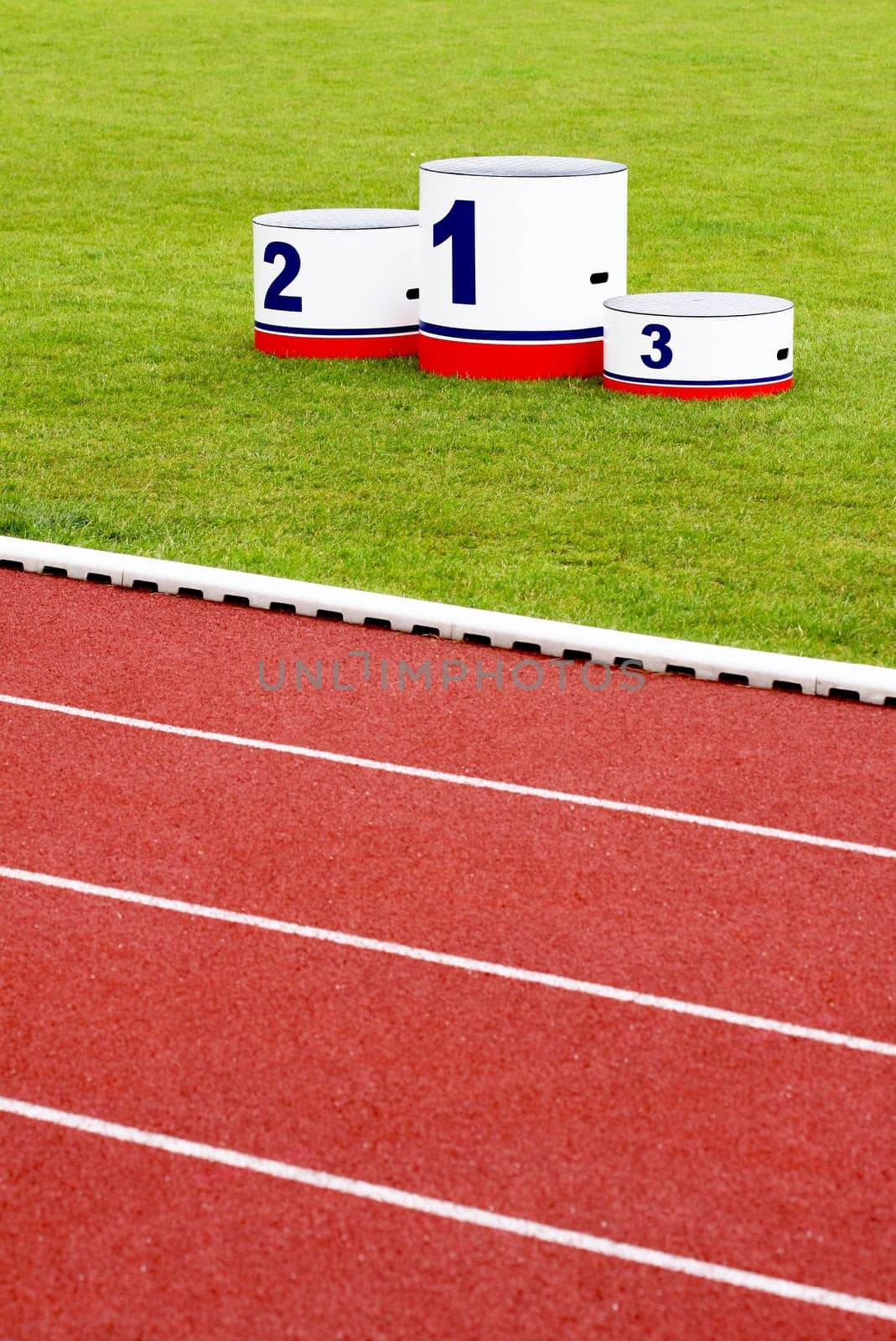 Track lanes with winner&#039 s podium on green grass