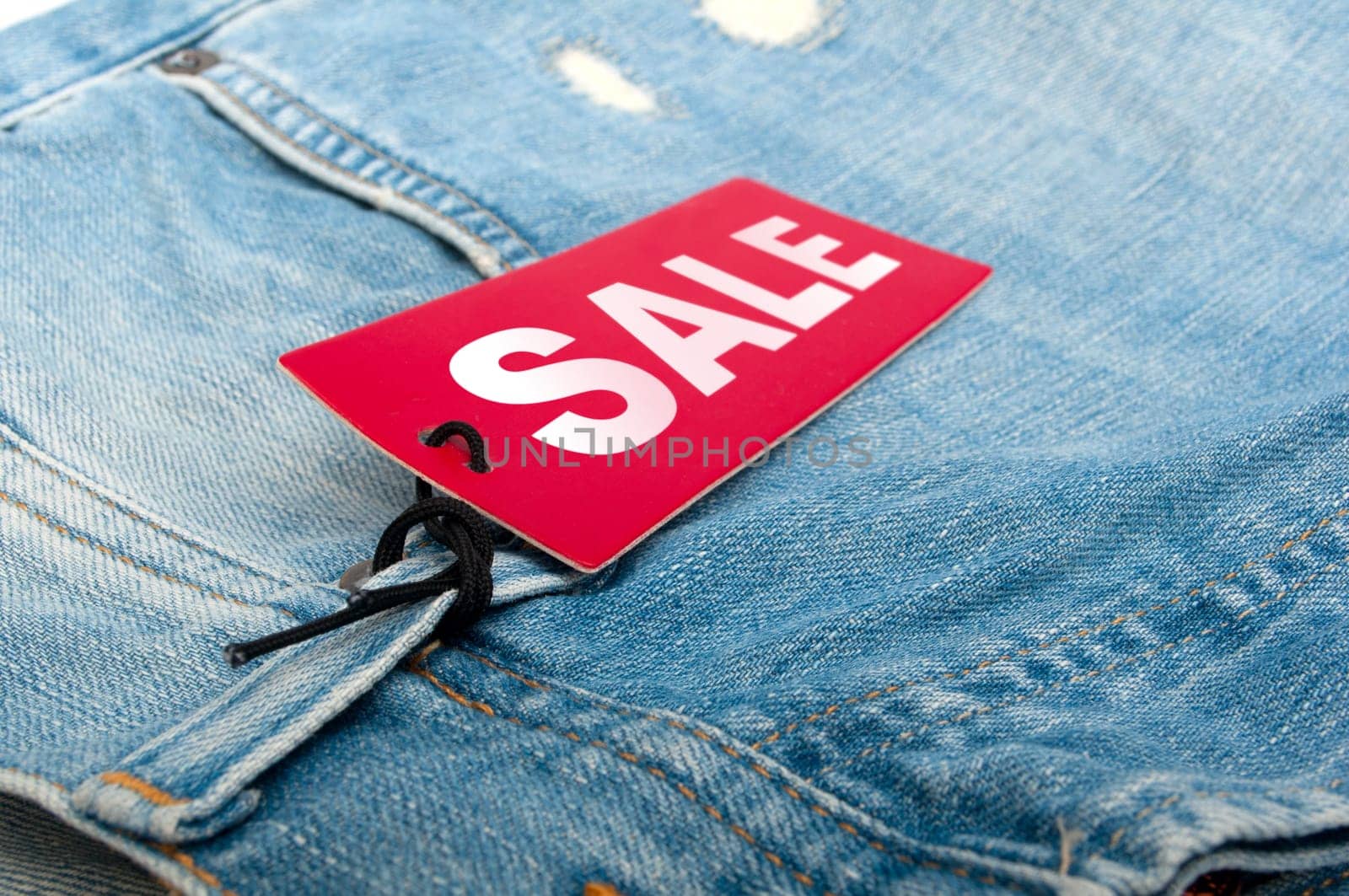 Closeup of Blue Jeans With Red Sale Tag - Shallow Depth of Field
