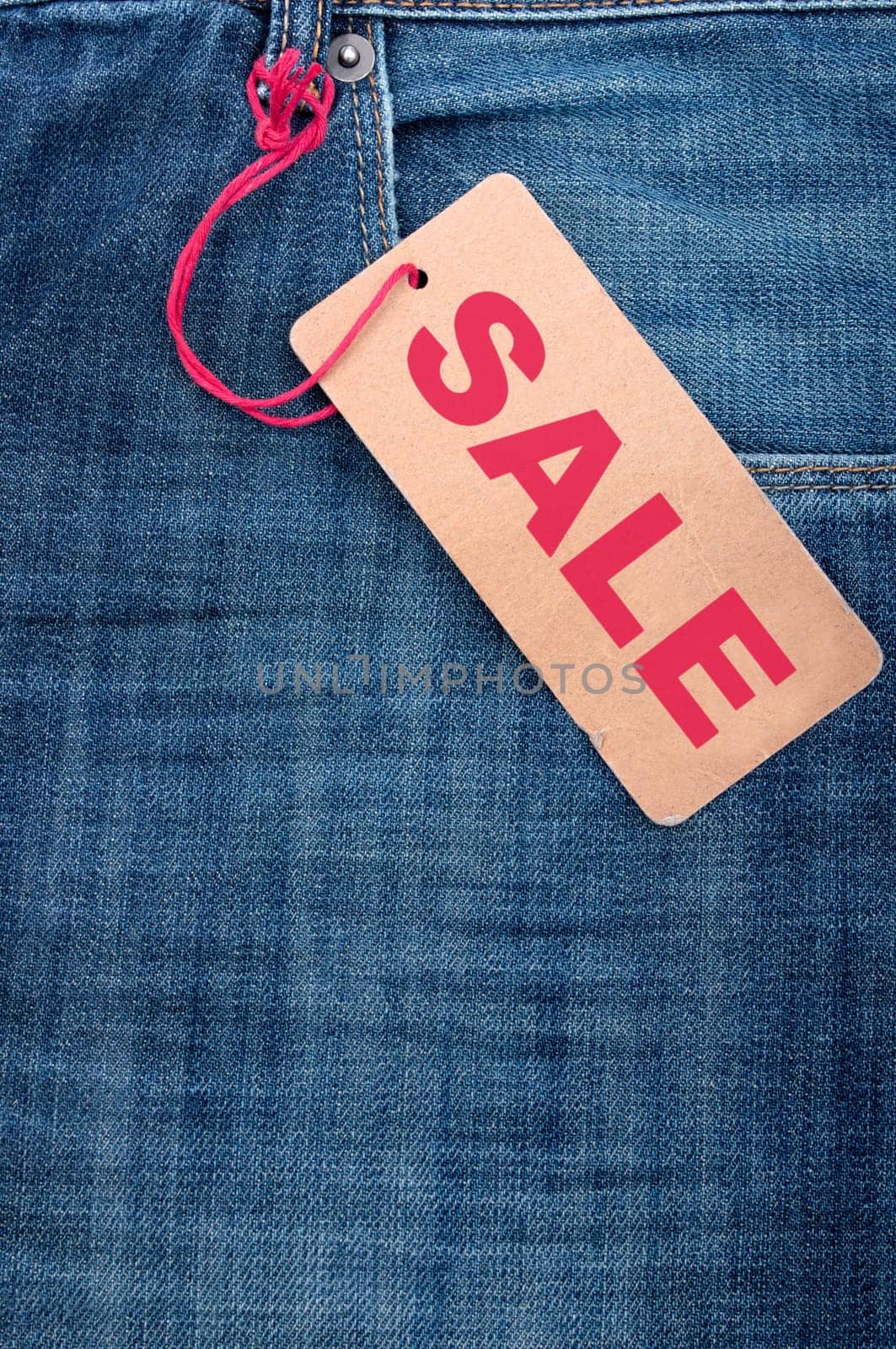 Closeup of Blue Jeans With Brown Sale Tag