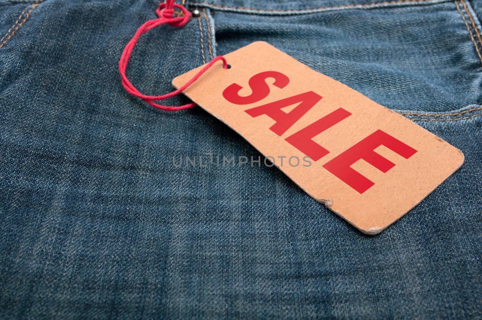 Closeup of Blue Jeans With Brown Sale Tag