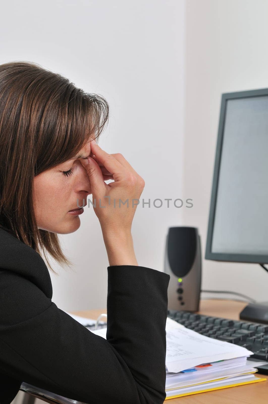Young business person (woman) has headache and tired eyes are closed - computer and papers on work table