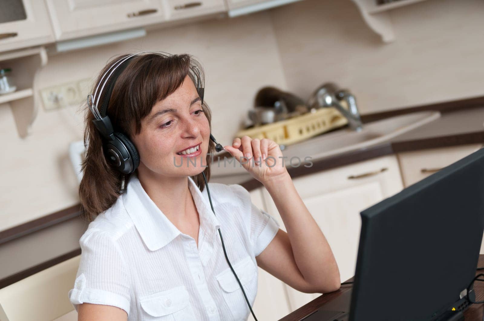 Young business person with headache working at home and calling (headset on head)