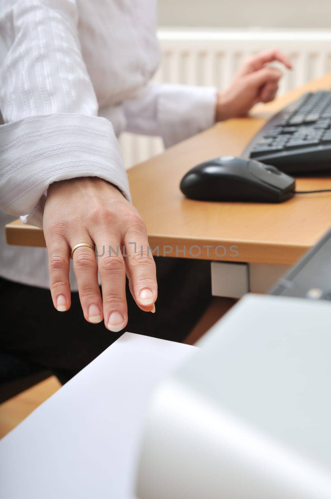 Hand of business woman reching paper from printer on workplace - detail