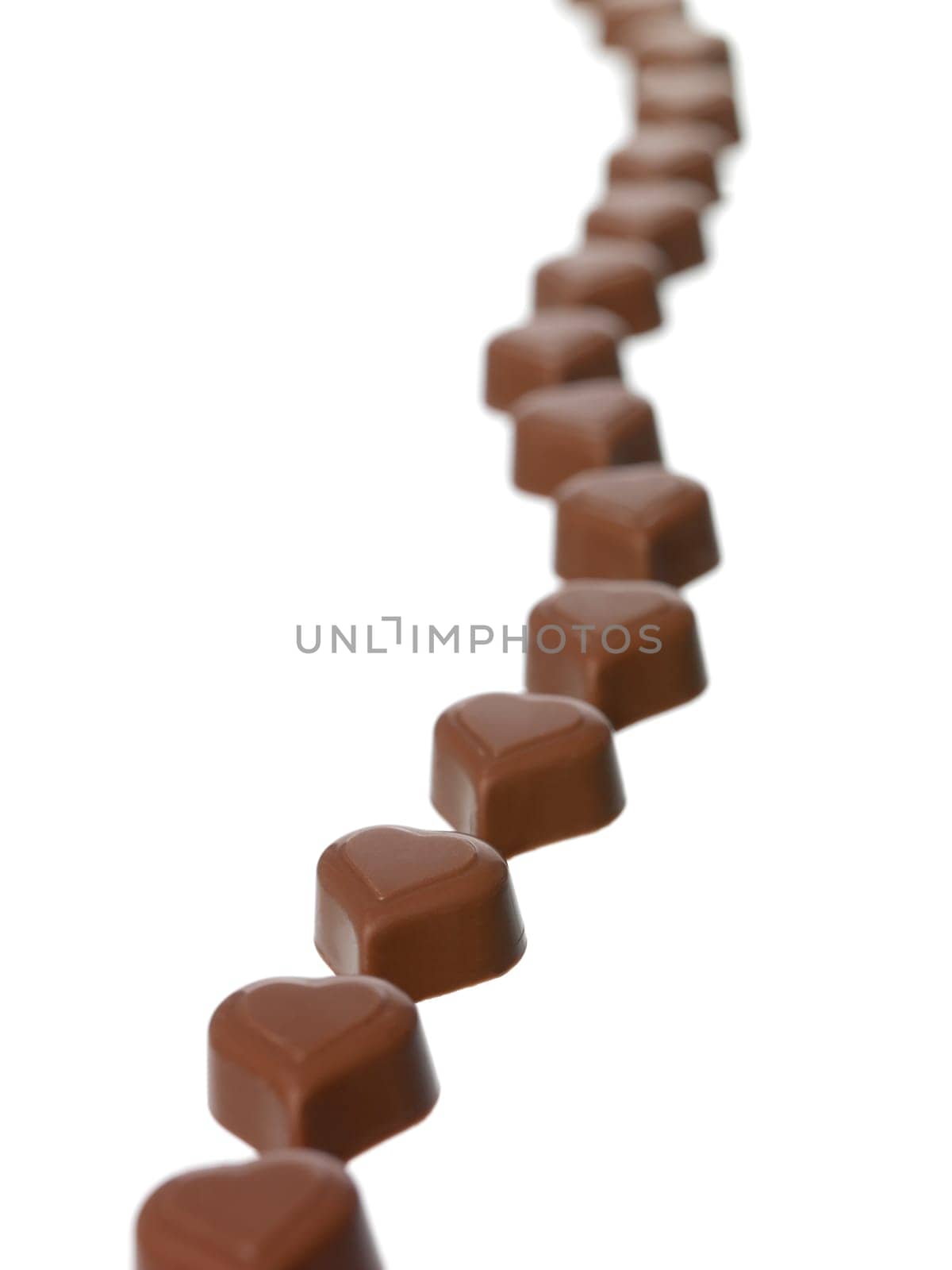 Heart shaped chocolate in a row on white background