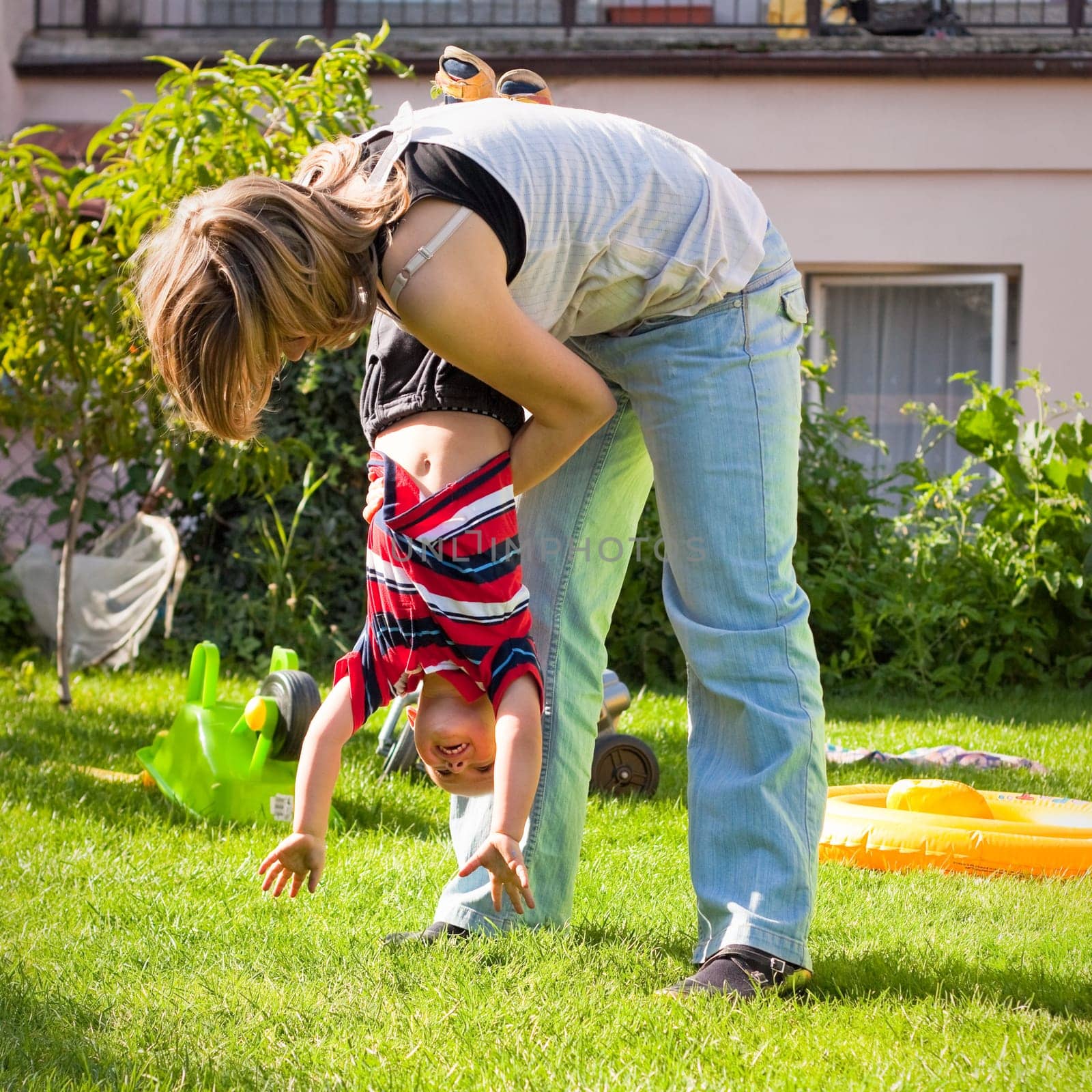 Young woman and little child boy having fun outdoors
