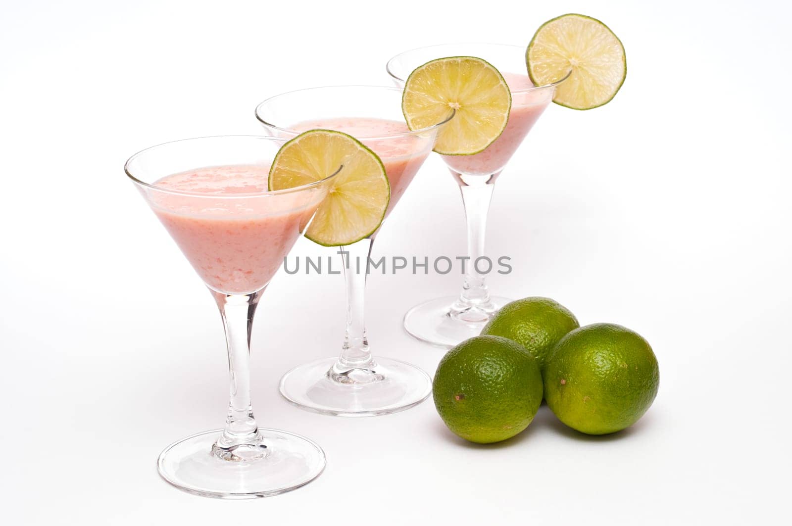 Three cocktail glasses with buttermilk,papaya and limes