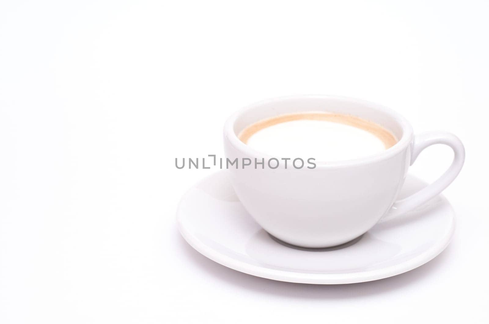 A cup of cappuccino against a white background