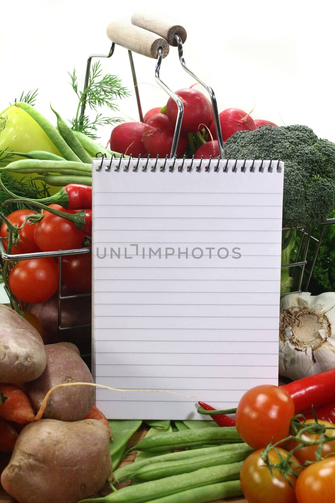 a lined notepad and various vegetables