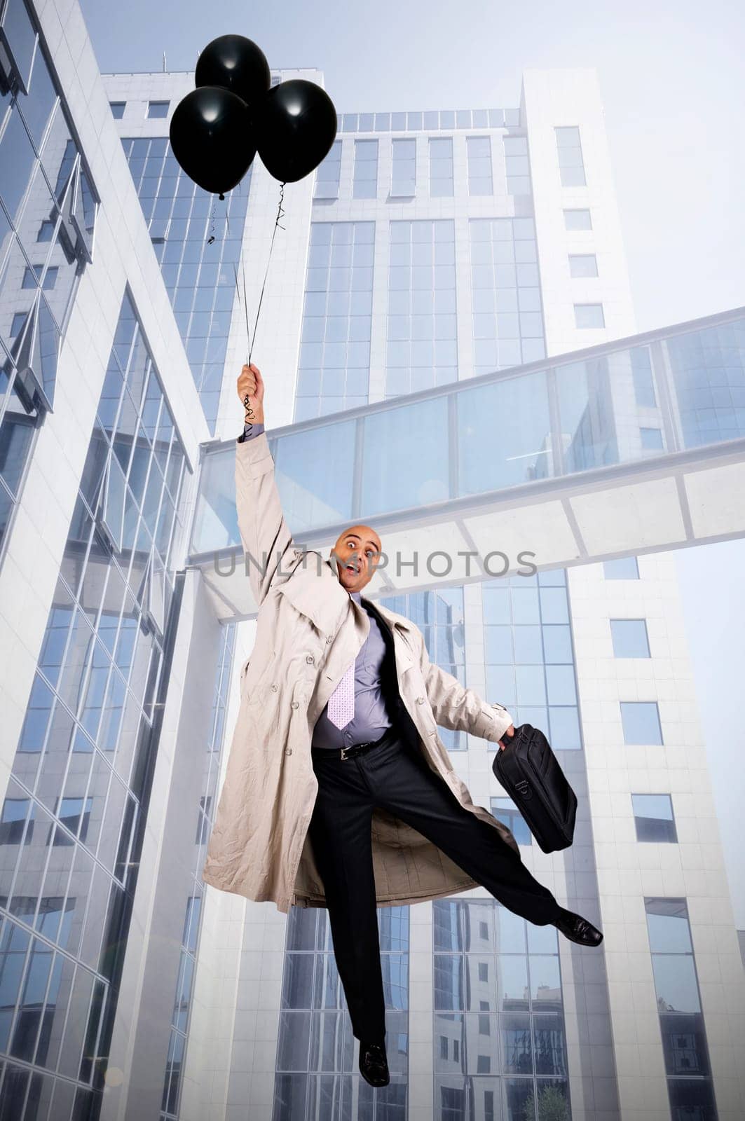 Businessman holding a group of black balloons